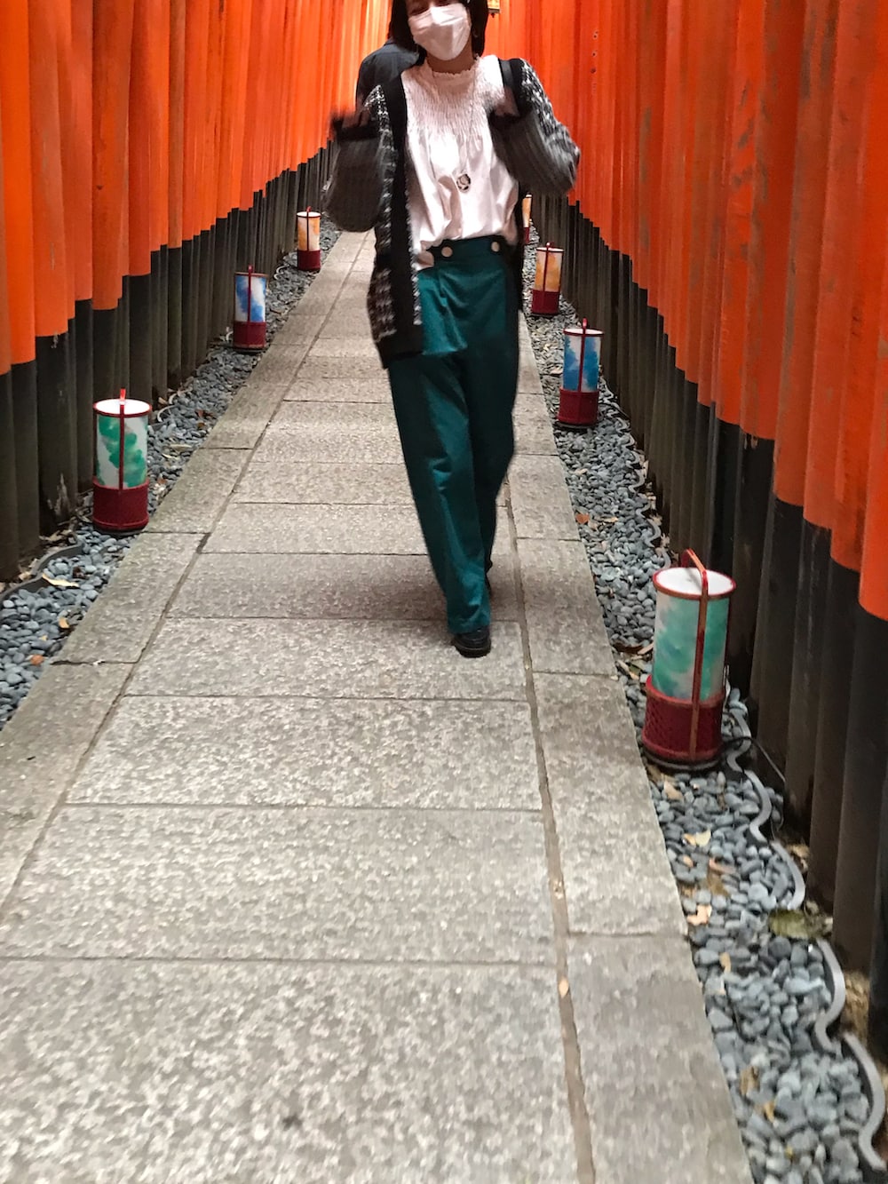 ブラック系のカーディガン/ボレロ、ブラック系のバッグ、グリーン系のパンツを着用したレディースの秋コーディネートの2枚目の写真