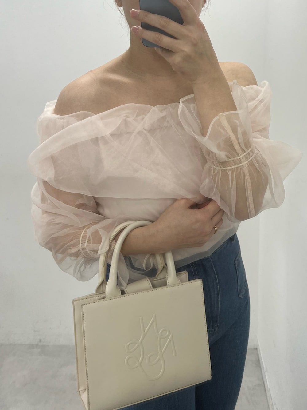 ブルー系のデニムパンツ、ホワイト系のショルダーバッグ、ピンク系のシャツ/ブラウスを着用したレディースの冬コーディネートの2枚目の写真