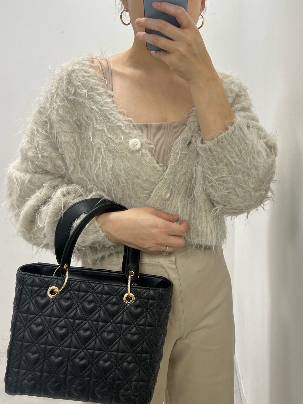 ベージュ系のデニムパンツ、ベージュ系のカーディガン/ボレロ、ベージュ系のキャミソールを着用したレディースの秋コーディネートの3枚目の写真