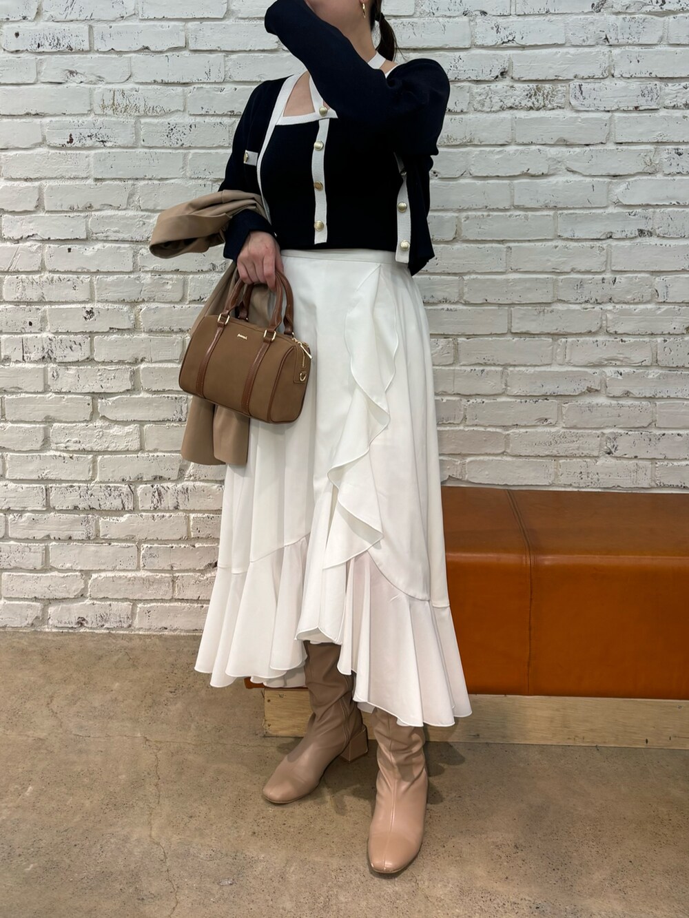 イエロー系のボストンバッグ、ブルー系のキャミソール、ブルー系のカーディガン/ボレロを着用したレディースの冬コーディネートの2枚目の写真