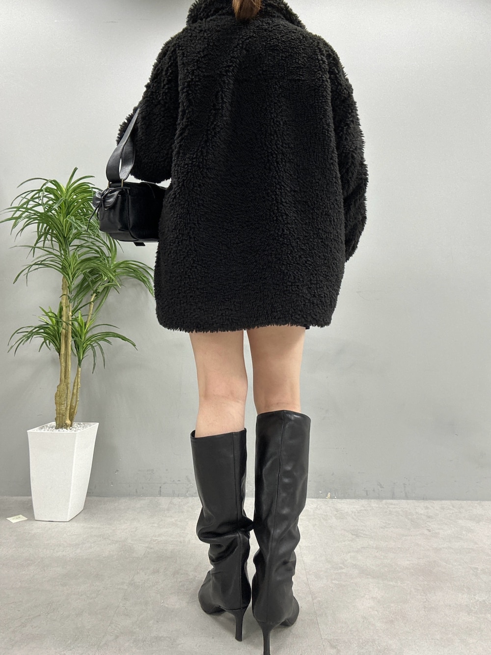 ブラック系のブルゾン、グレー系のニット/セーター、ブラック系のショルダーバッグを着用したレディースの秋コーディネートの3枚目の写真