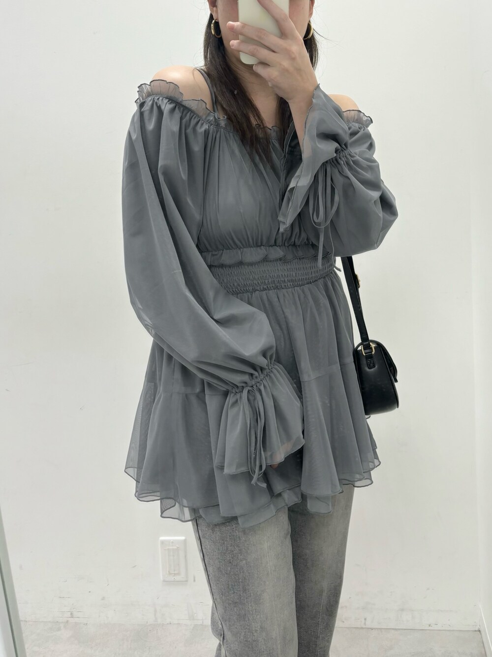 グレー系のシャツ/ブラウス、ブラック系のデニムパンツを着用したレディースの春コーディネートの2枚目の写真