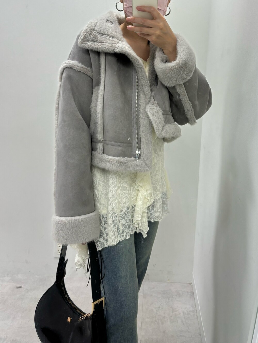 ブルー系のデニムパンツ、ブラウン系のムートンコートを着用したレディースの秋コーディネートの2枚目の写真
