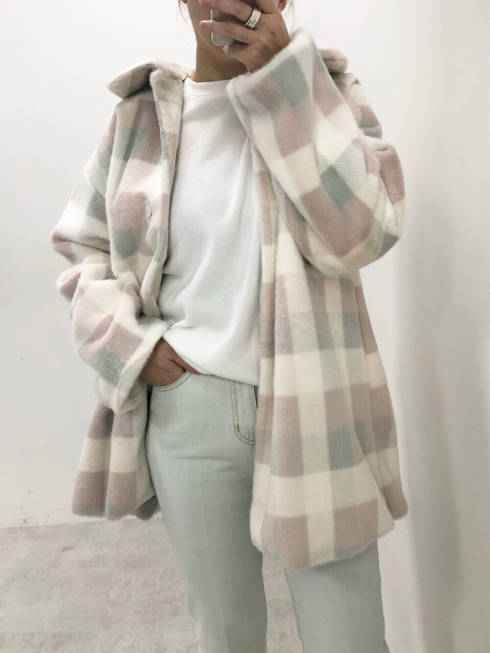 ブルー系のデニムパンツ、ピンク系のチェスターコート、ホワイト系のTシャツ/カットソーを着用したレディースの秋コーディネートの4枚目の写真