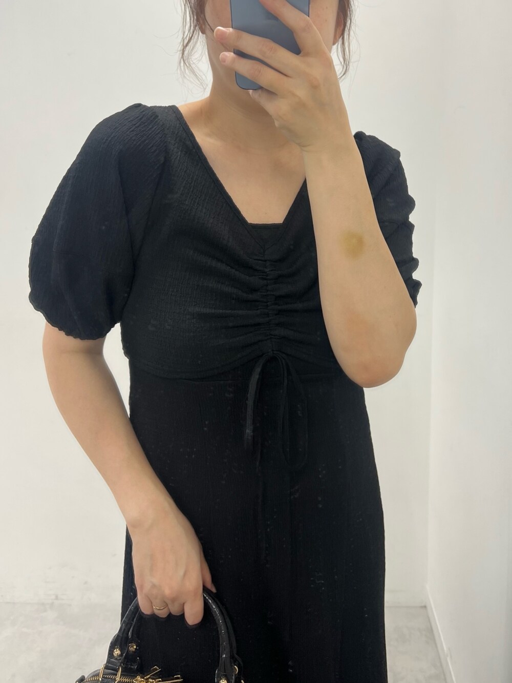 ブラック系のワンピース、ブラック系のボストンバッグ、ブラック系のサンダルを着用したレディースの夏コーディネートの2枚目の写真