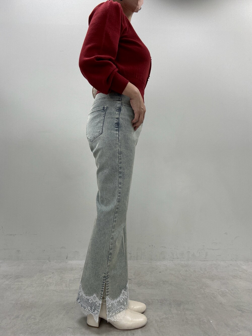 ブルー系のデニムパンツ、レッド系のカーディガン/ボレロ、ブラック系のブーツを着用したレディースの秋コーディネートの2枚目の写真