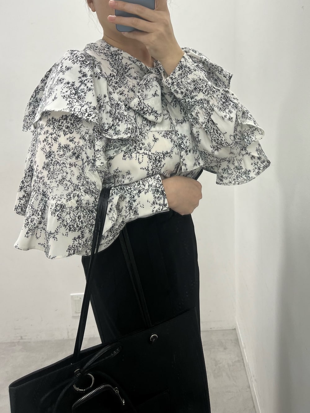 ブラック系のスカート、ブラック系のシャツ/ブラウス、ブラック系のトートバッグを着用したレディースの冬コーディネートの3枚目の写真