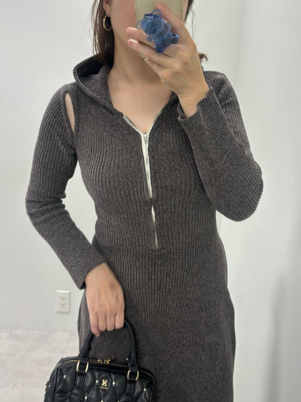 グレー系のワンピース、ブラック系のボストンバッグ、ブラック系のブーツを着用したレディースの秋コーディネートの5枚目の写真