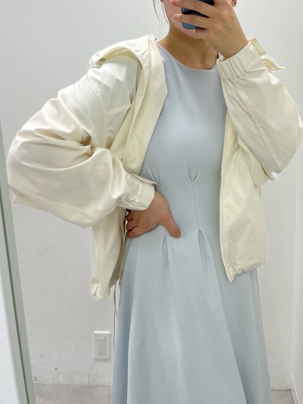 ホワイト系のマウンテンパーカー、ホワイト系のサンダル、ブルー系のワンピースを着用したレディースの春コーディネートの2枚目の写真