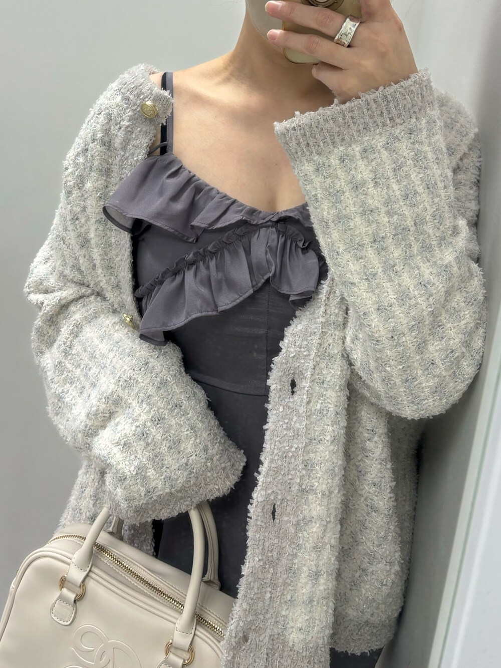 グレー系のワンピース、ブルー系のカーディガン/ボレロ、イエロー系のボストンバッグを着用したレディースの冬コーディネートの4枚目の写真