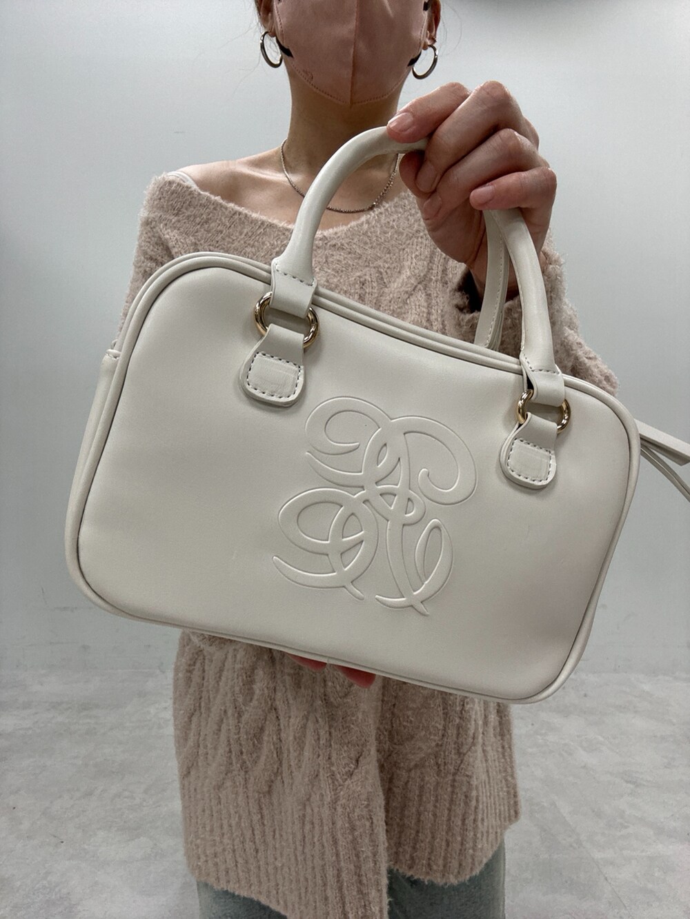 ブルー系のデニムパンツ、ベージュ系のニット/セーター、ブラック系のブーツを着用したレディースの秋コーディネートの5枚目の写真