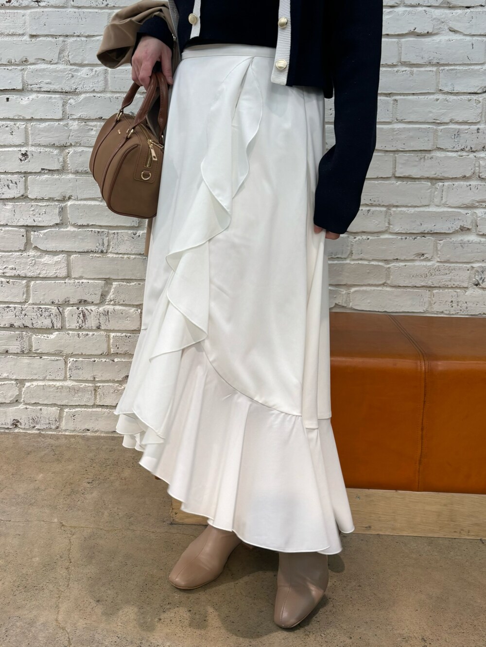 イエロー系のボストンバッグ、ブルー系のキャミソール、ブルー系のカーディガン/ボレロを着用したレディースの冬コーディネートの5枚目の写真