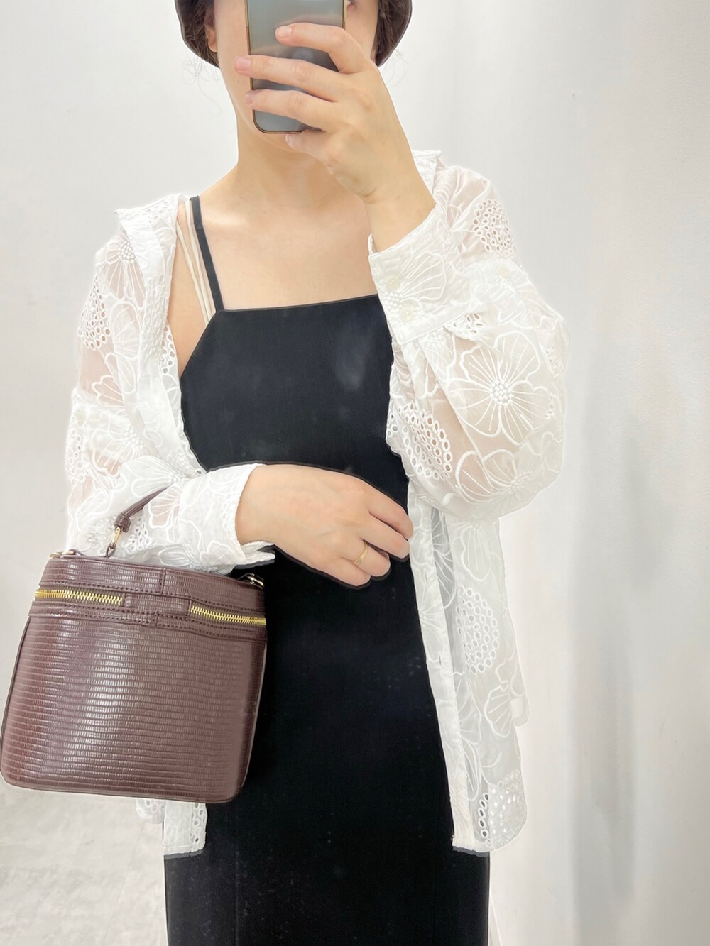 ブラック系のワンピース、ブラック系のサンダル、ホワイト系のシャツ/ブラウスを着用したレディースの夏コーディネートの3枚目の写真
