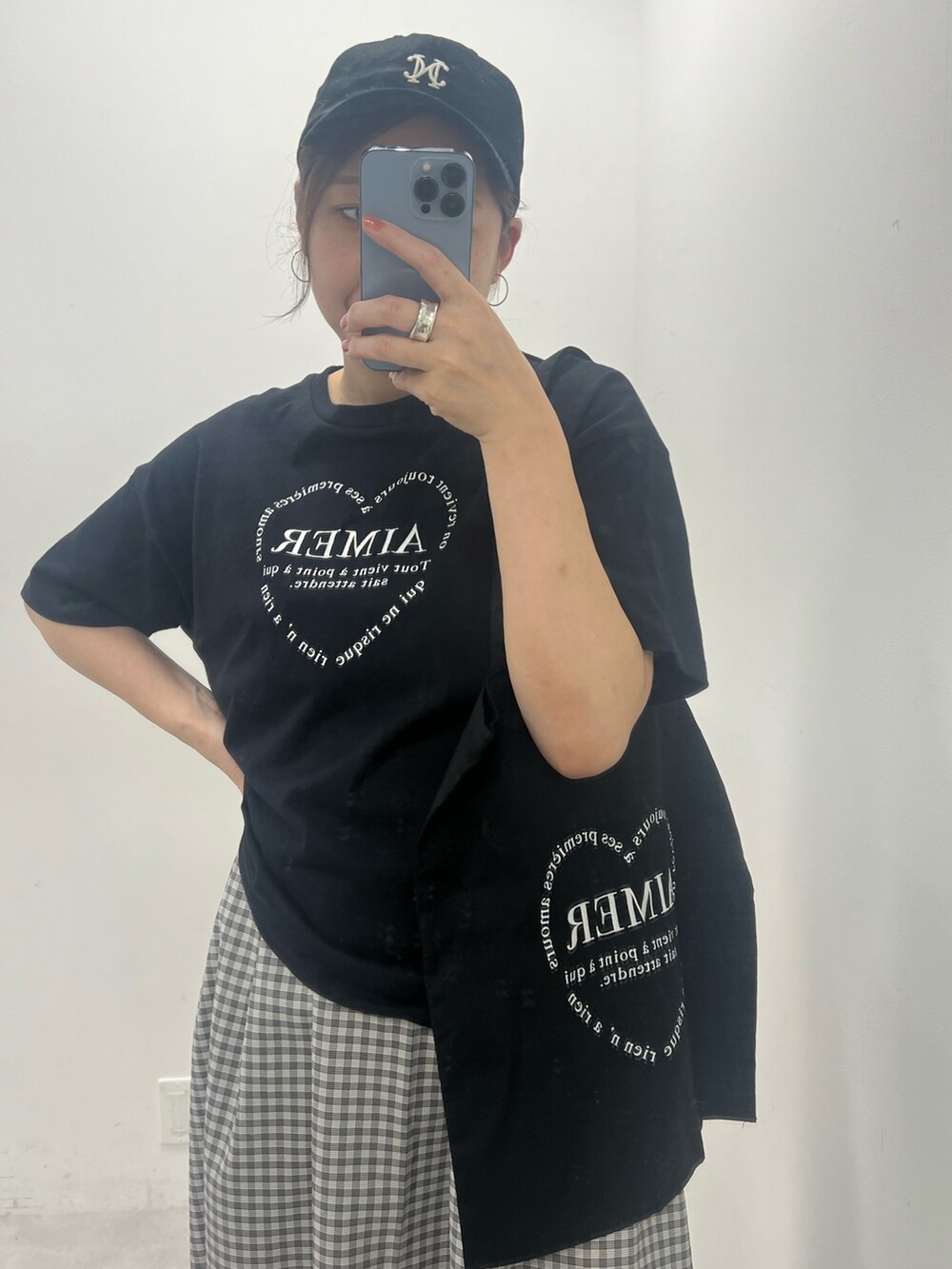 ブラック系のワンピース、ホワイト系のスニーカー、ブラック系のトートバッグを着用したレディースの夏コーディネートの4枚目の写真