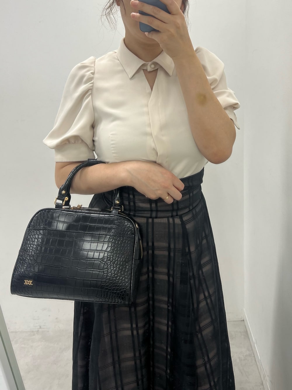 ブラック系のスカート、ブラック系のサンダル、ブラック系のボストンバッグを着用したレディースの夏コーディネートの2枚目の写真