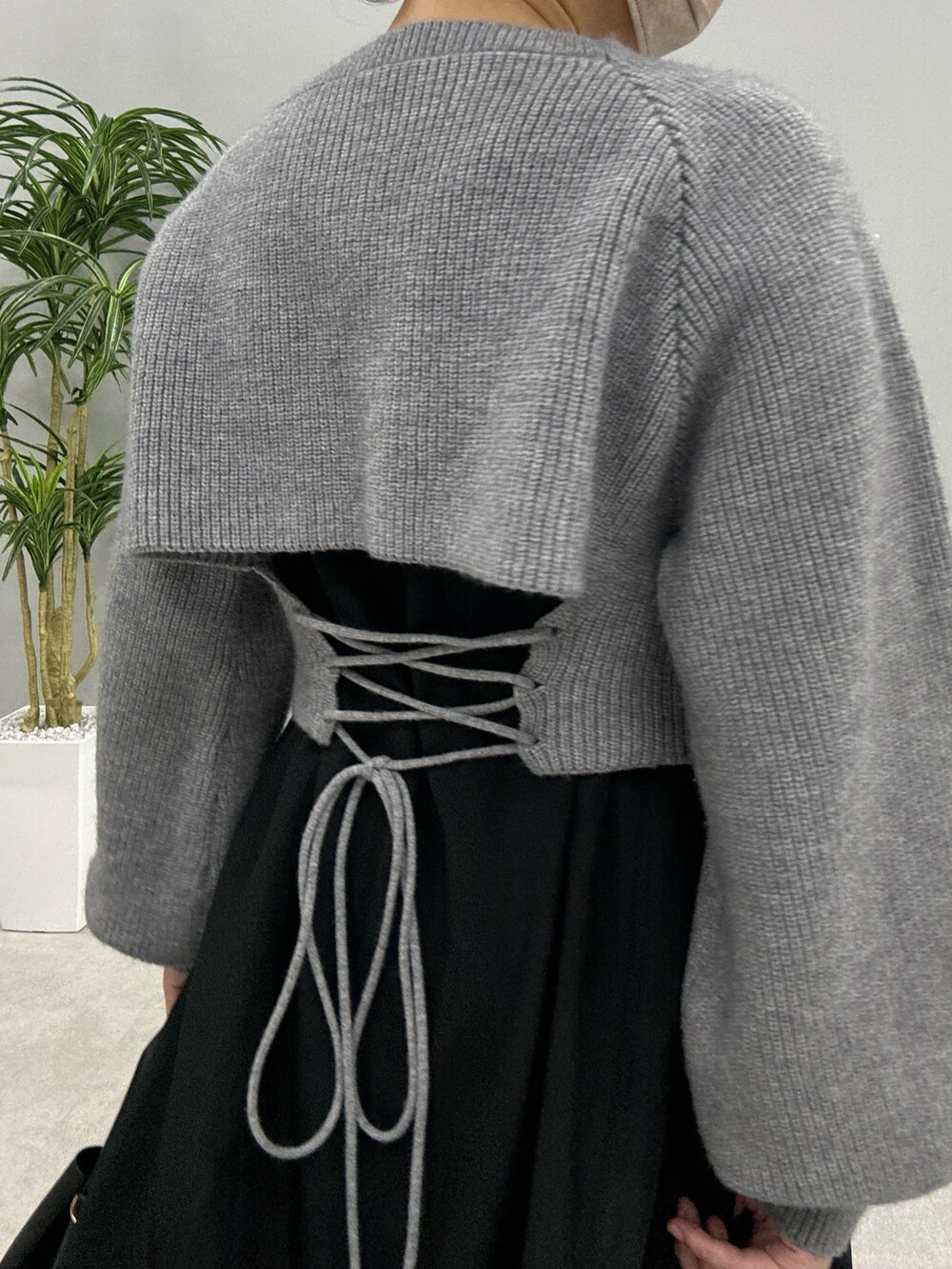 ベージュ系のワンピース、ホワイト系のハンドバッグ、ブラック系のブーツを着用したレディースの秋コーディネートの5枚目の写真