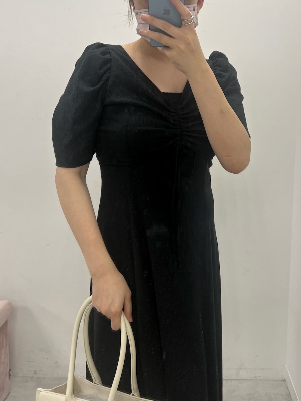 ブラック系のワンピース、ホワイト系のトートバッグ、ブラック系のキャップを着用したレディースの夏コーディネートの2枚目の写真