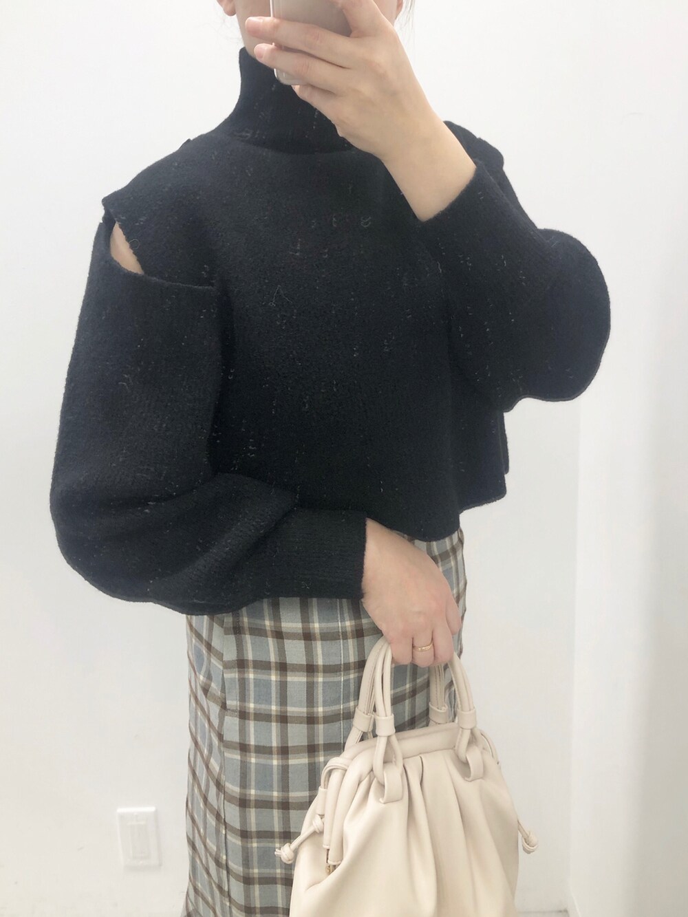 ブラック系のニット/セーター、グレー系のスカート、ホワイト系のブーツを着用したレディースの冬コーディネートの2枚目の写真