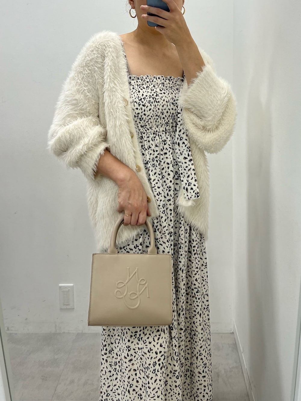 ホワイト系のカーディガン/ボレロ、ブラック系のワンピース、ベージュ系のショルダーバッグを着用したレディースの秋コーディネートの2枚目の写真