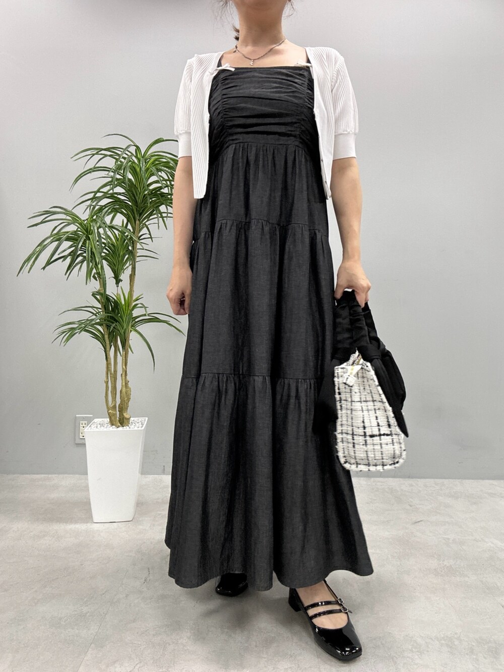 ブラック系のワンピース、ブラック系のパンプス、ホワイト系のトートバッグを着用したレディースの夏コーディネートの2枚目の写真