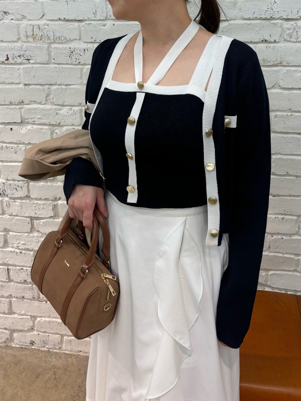 イエロー系のボストンバッグ、ブルー系のキャミソール、ブルー系のカーディガン/ボレロを着用したレディースの冬コーディネートの6枚目の写真