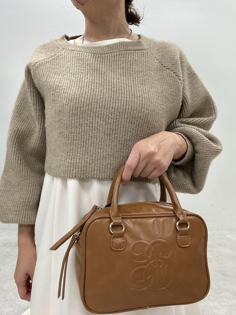 ブラック系のブーツ、ベージュ系のワンピース、イエロー系のボストンバッグを着用したレディースの秋コーディネートの5枚目の写真