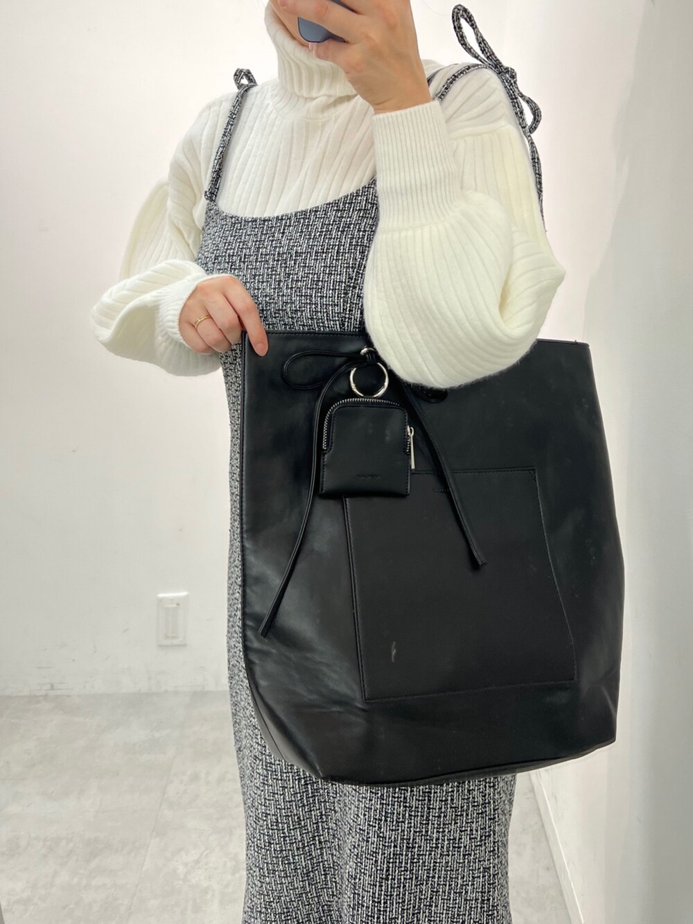 ブラック系のワンピース、ブラック系のブーツ、ブラック系のトートバッグを着用したレディースの秋コーディネートの2枚目の写真