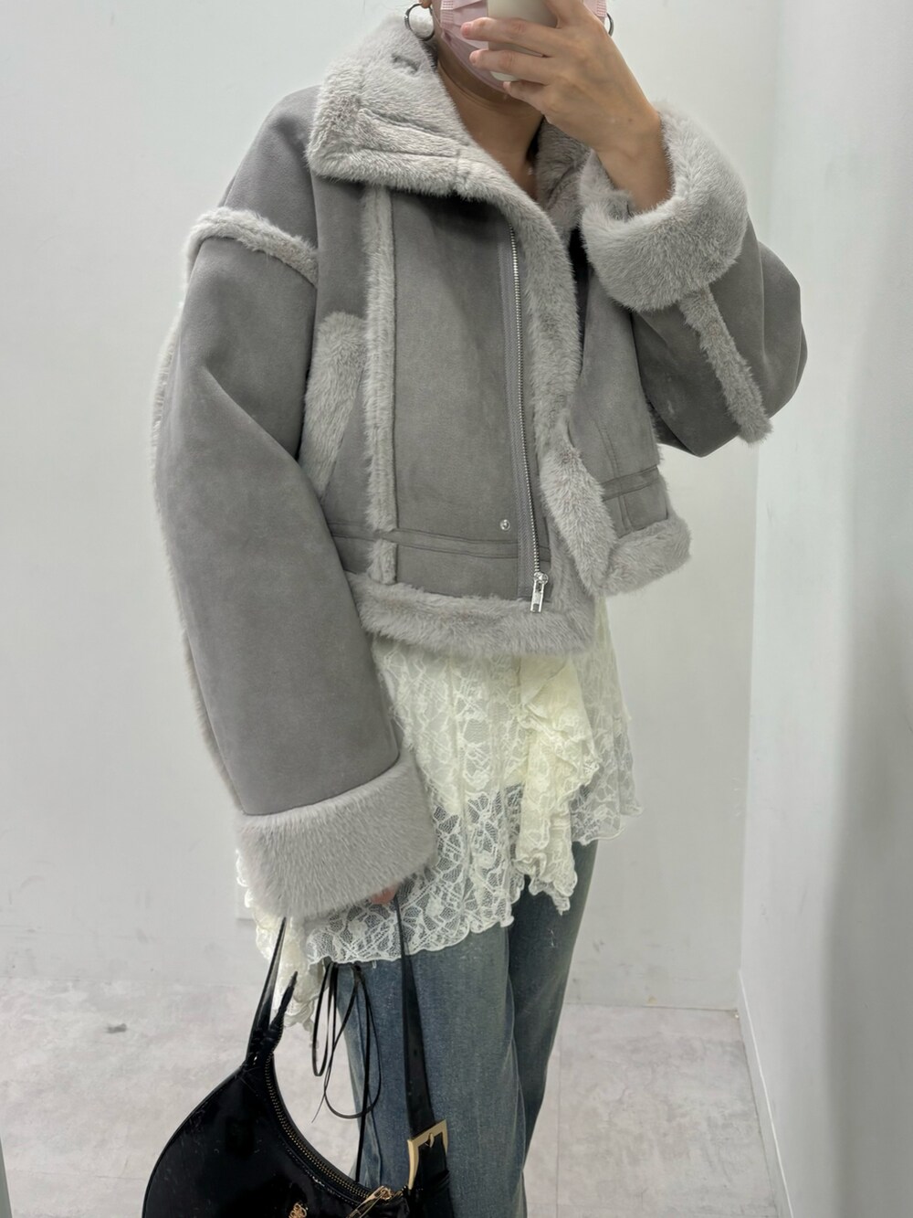 ブルー系のデニムパンツ、ブラウン系のムートンコートを着用したレディースの秋コーディネートの4枚目の写真