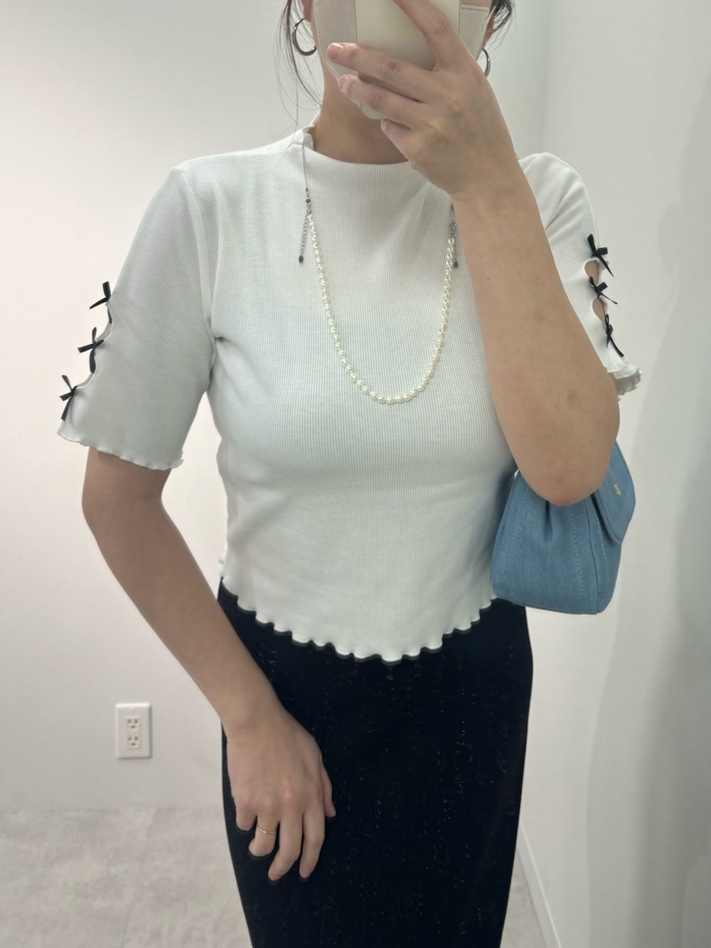 ブラック系のスカート、シルバー系のサンダル、ブルー系のショルダーバッグを着用したレディースの春コーディネートの2枚目の写真