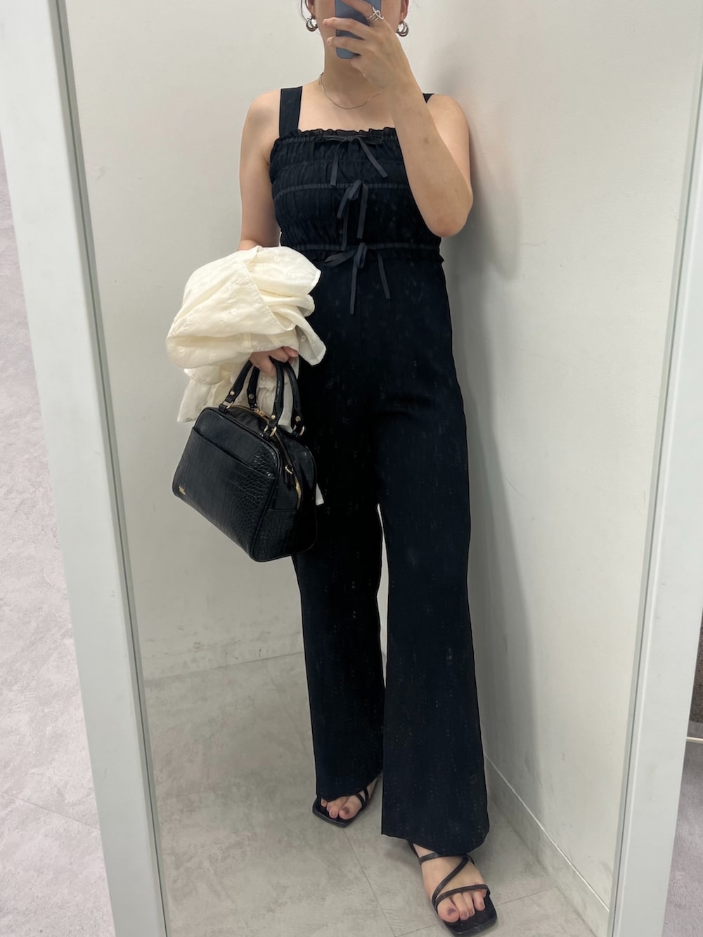 ブラック系のサロペット/オーバーオール、ブラウン系のボストンバッグ、ホワイト系のシャツ/ブラウスを着用したレディースの夏コーディネートの2枚目の写真