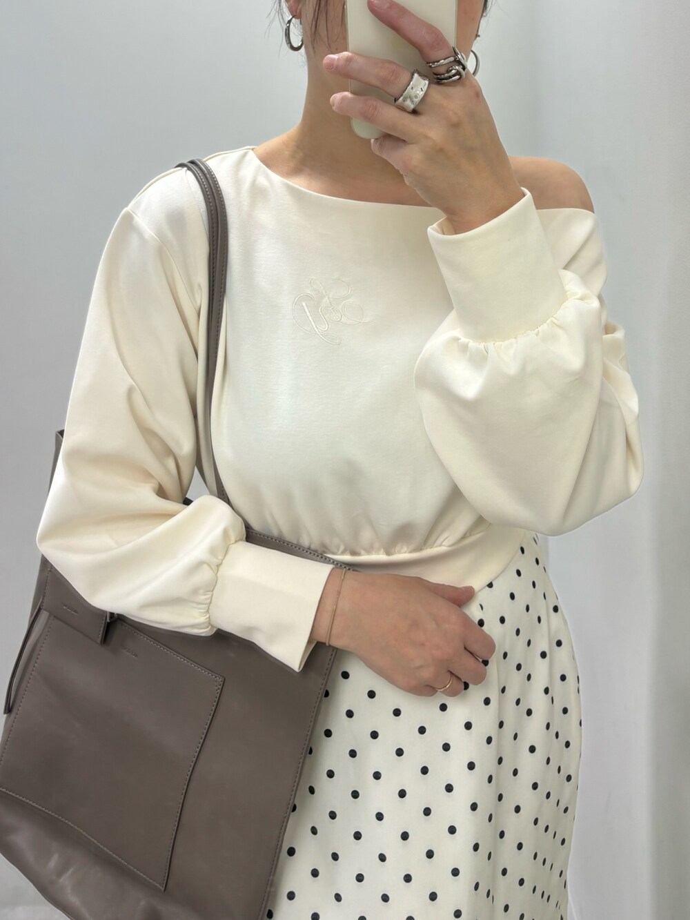 ベージュ系のスカート、ブラウン系のトートバッグ、ホワイト系のTシャツ/カットソーを着用したレディースの冬コーディネートの3枚目の写真