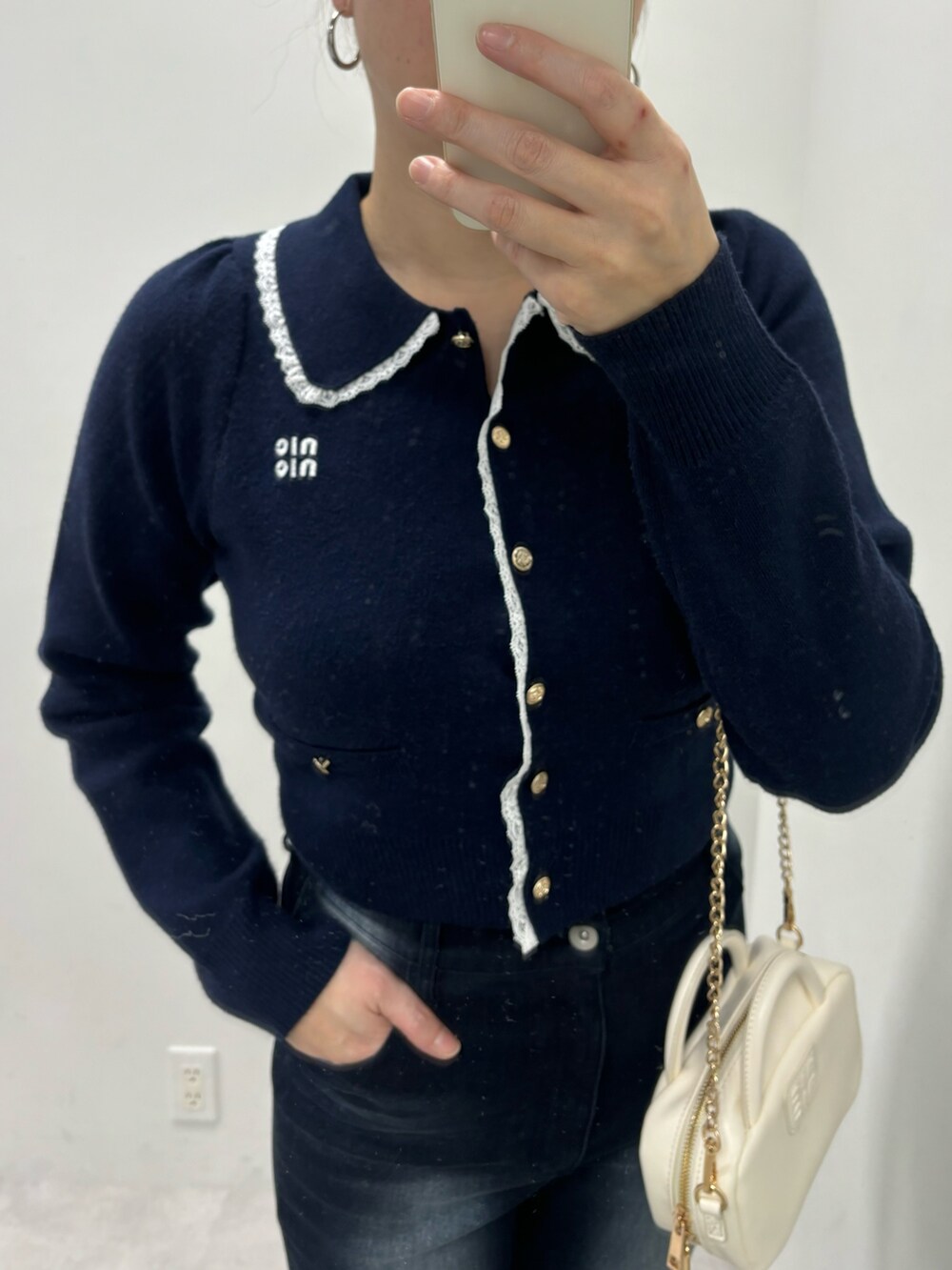 ブルー系のデニムパンツ、ホワイト系のボストンバッグ、ホワイト系のパンプスを着用したレディースの冬コーディネートの5枚目の写真
