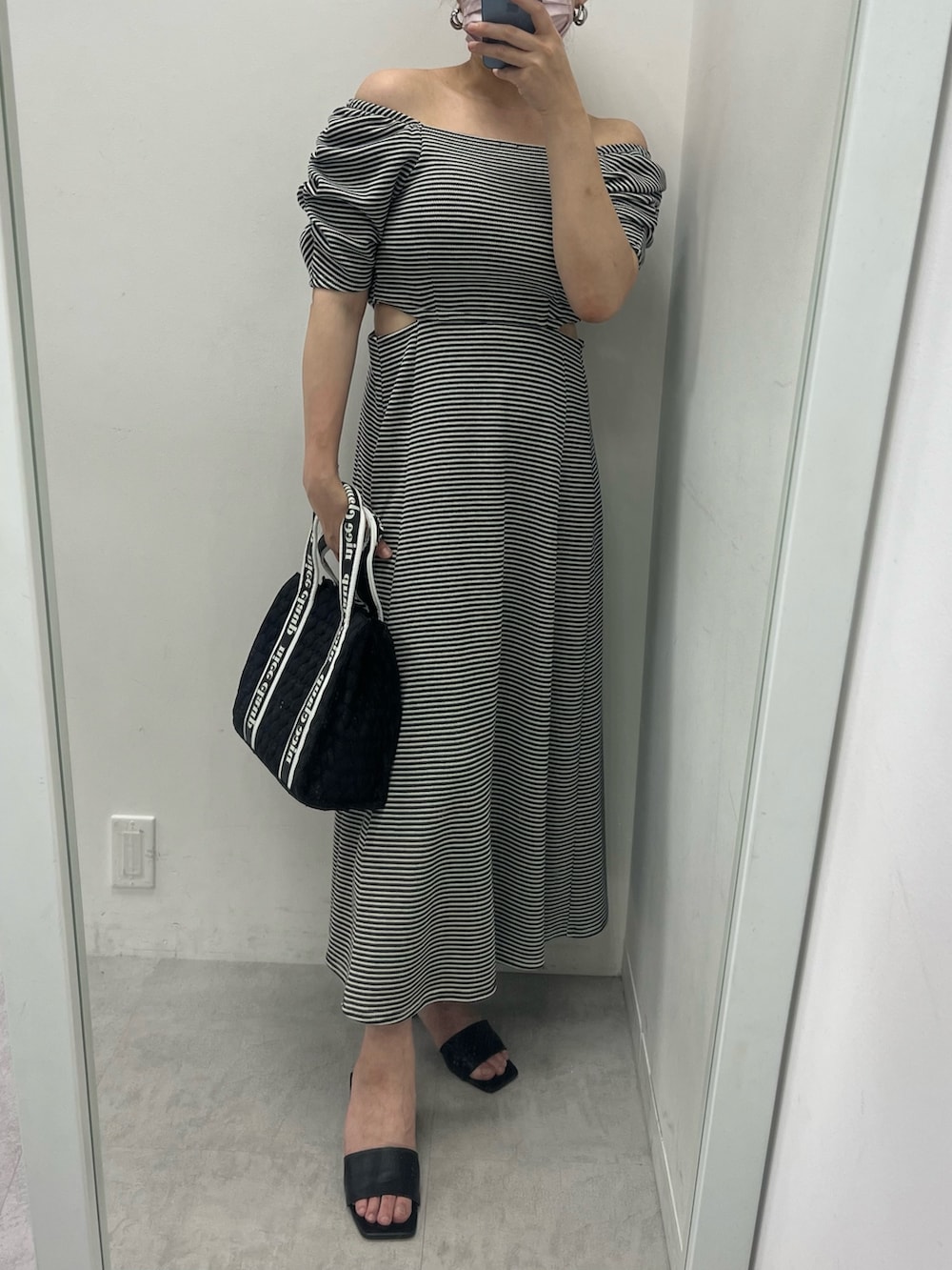 ホワイト系のワンピース、ピンク系のトートバッグ、ブラック系のサンダルを着用したレディースの夏コーディネートの2枚目の写真