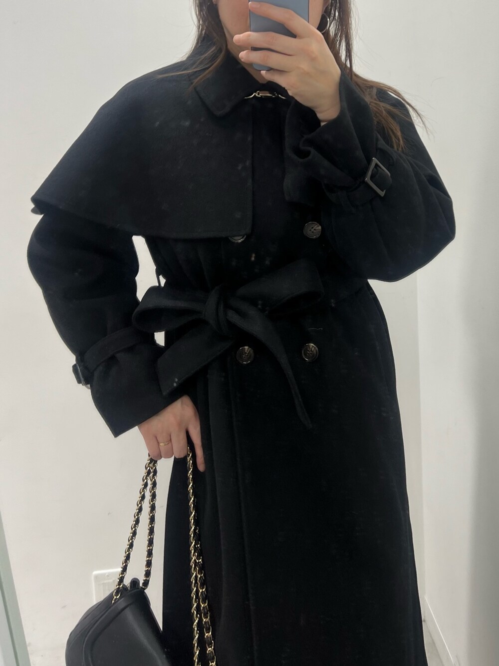 ブラック系のステンカラーコート、グレー系のスカート、ブラック系のバッグを着用したレディースの冬コーディネートの2枚目の写真