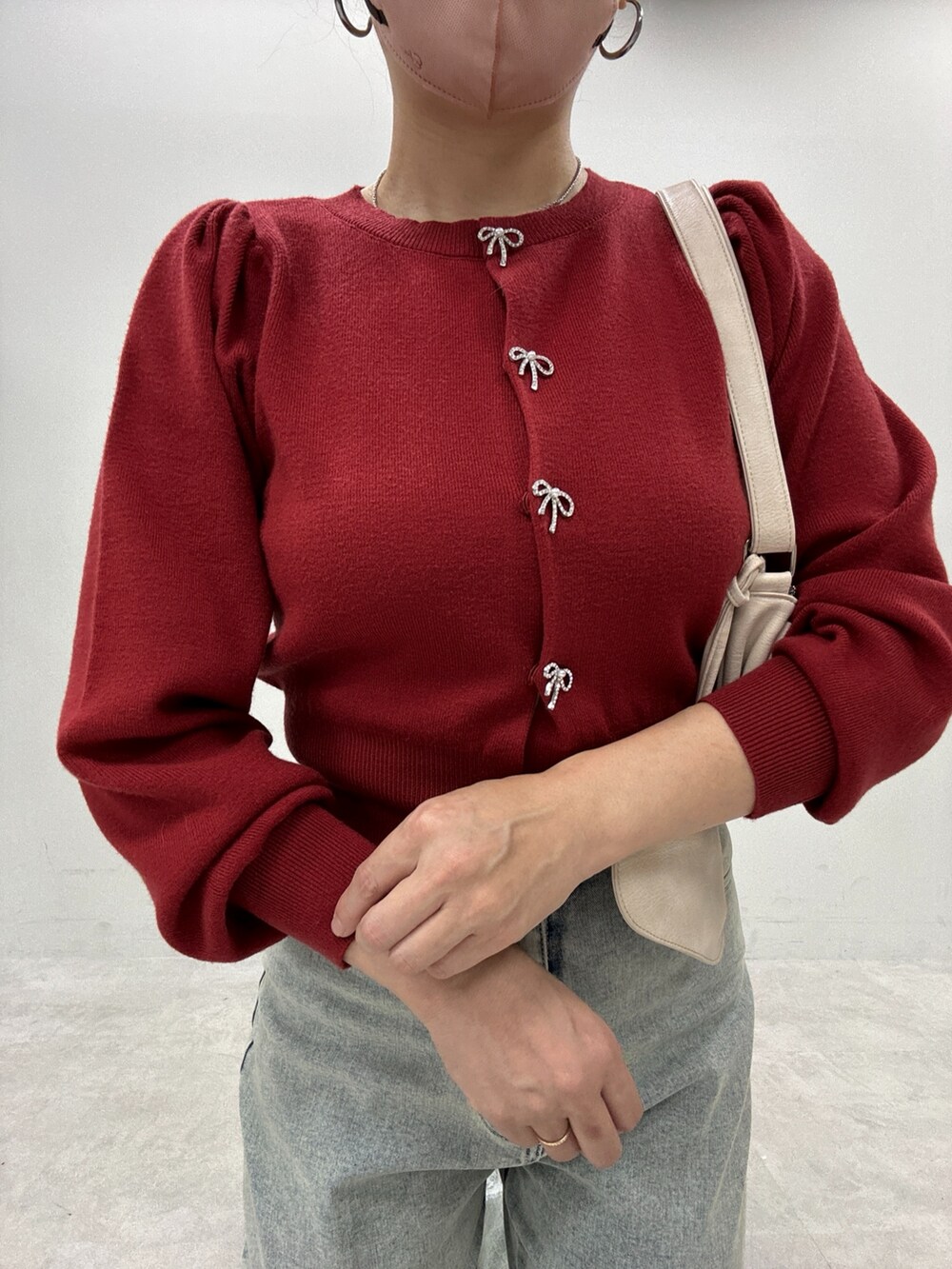 ブルー系のデニムパンツ、レッド系のカーディガン/ボレロ、ブラック系のブーツを着用したレディースの秋コーディネートの4枚目の写真