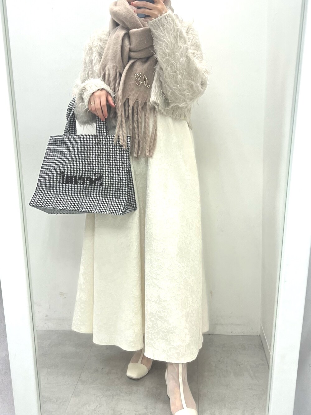 ホワイト系のワンピース、ブラック系のブーツ、ホワイト系のトートバッグを着用したレディースの夏コーディネートの3枚目の写真