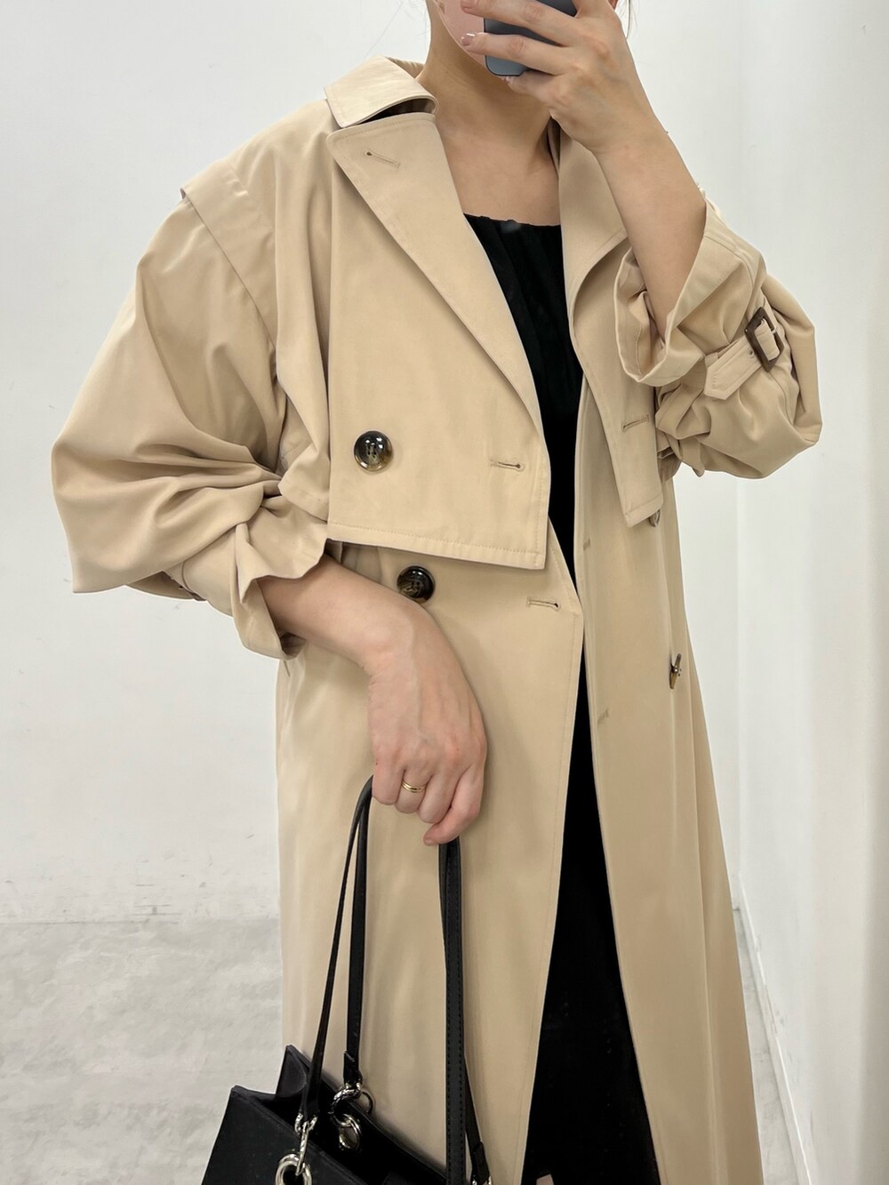 ブラック系のワンピース、ベージュ系のトートバッグ、ホワイト系のサンダルを着用したレディースの春コーディネートの2枚目の写真