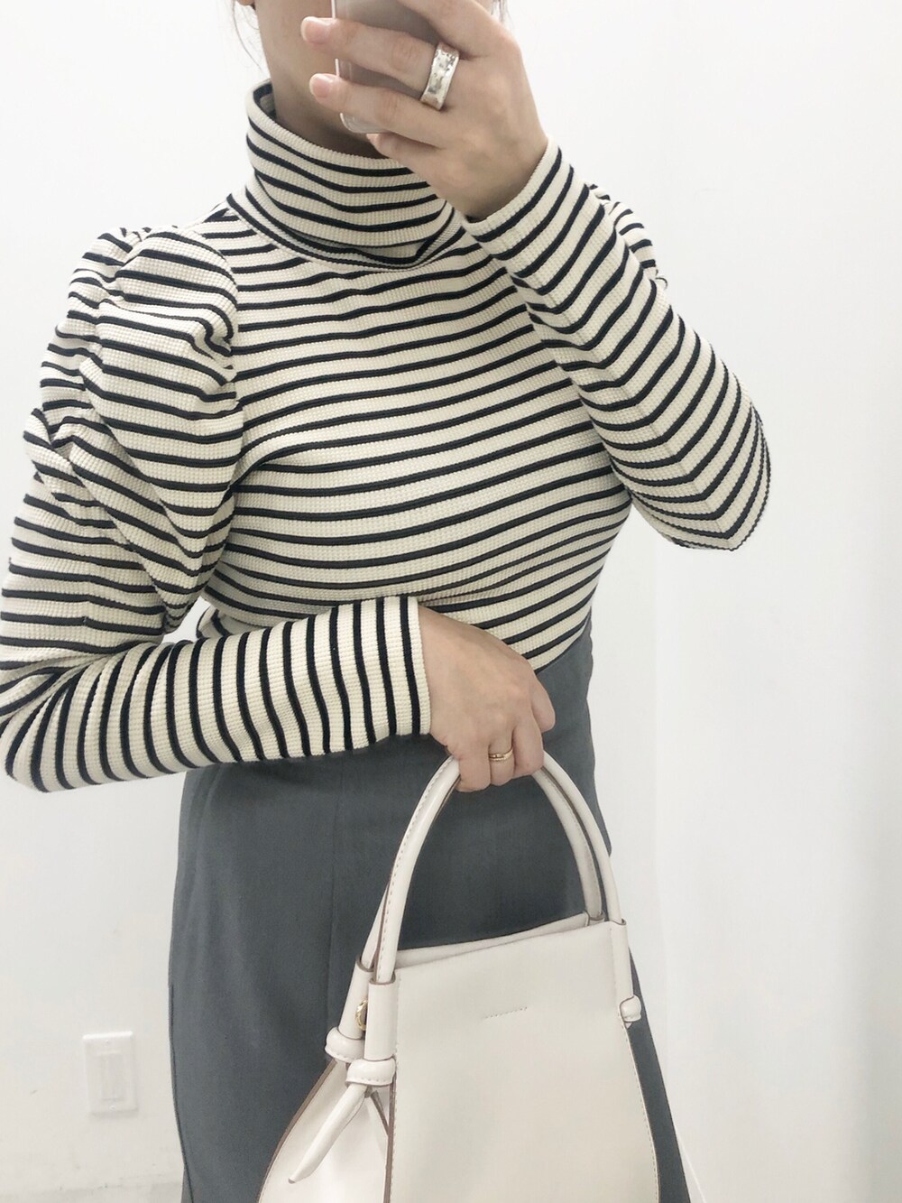 ホワイト系のTシャツ/カットソー、ホワイト系のショルダーバッグ、ブラック系のスカートを着用したレディースの冬コーディネートの2枚目の写真