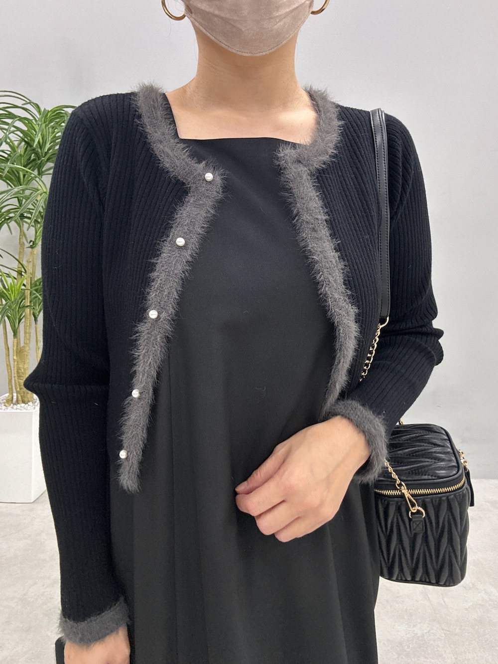 ベージュ系のワンピース、ブラック系のショルダーバッグ、ブラック系のカーディガン/ボレロを着用したレディースの秋コーディネートの5枚目の写真