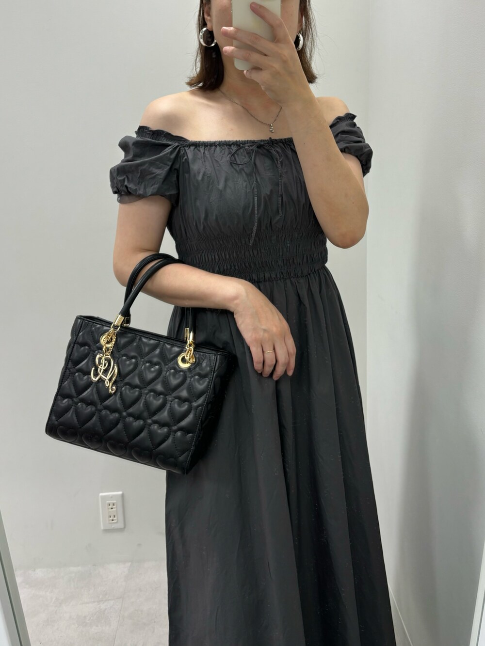 ブラック系のワンピース、ブラック系のサンダル、ブラック系のトートバッグを着用したレディースの夏コーディネートの2枚目の写真