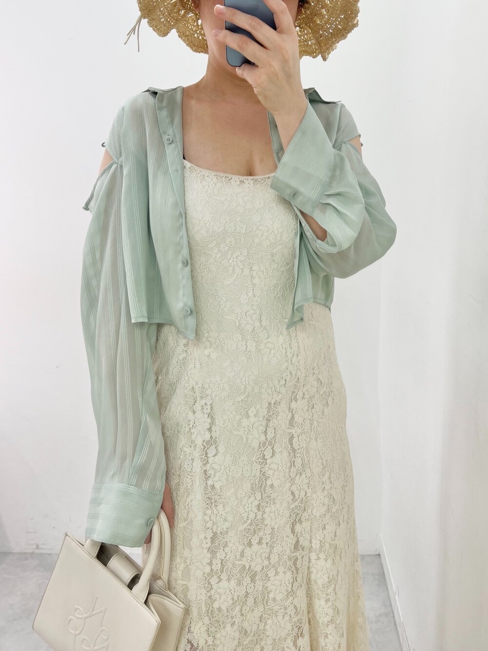 ホワイト系のワンピース、ホワイト系のショルダーバッグ、グリーン系のシャツ/ブラウスを着用したレディースの春コーディネートの2枚目の写真