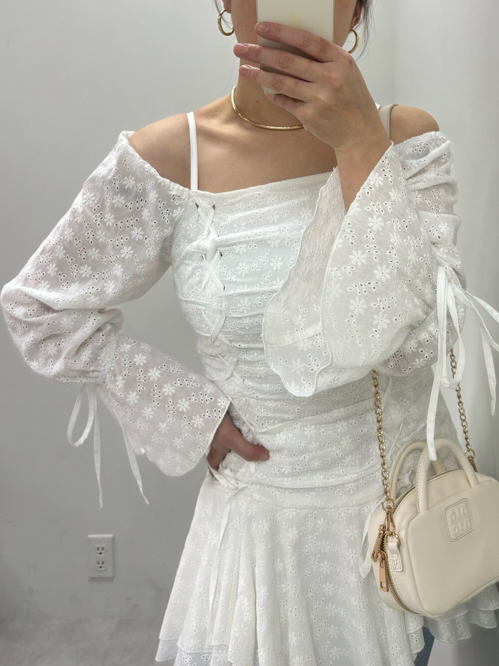 ブルー系のデニムパンツ、ホワイト系のボストンバッグ、ホワイト系のワンピースを着用したレディースの冬コーディネートの4枚目の写真