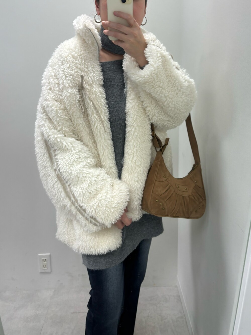 グレー系のワンピース、ホワイト系のパンプス、ベージュ系のショルダーバッグを着用したレディースの冬コーディネートの3枚目の写真