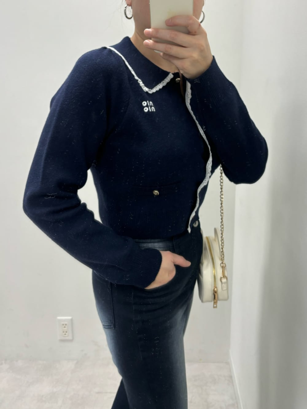 ブルー系のデニムパンツ、ホワイト系のボストンバッグ、ホワイト系のパンプスを着用したレディースの冬コーディネートの4枚目の写真