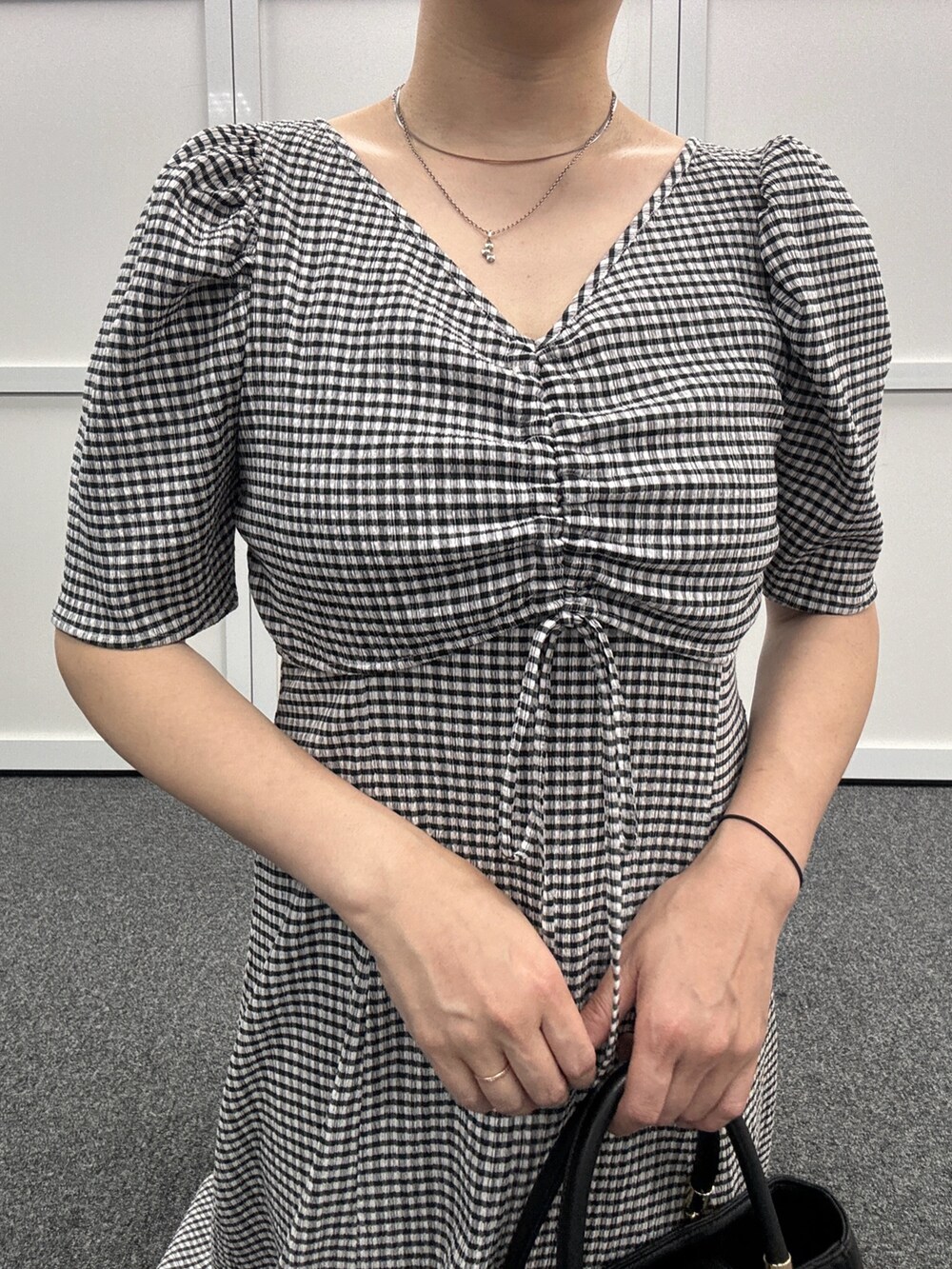 ブラック系のワンピース、ブラック系のサンダル、ブラック系のトートバッグを着用したレディースの夏コーディネートの2枚目の写真