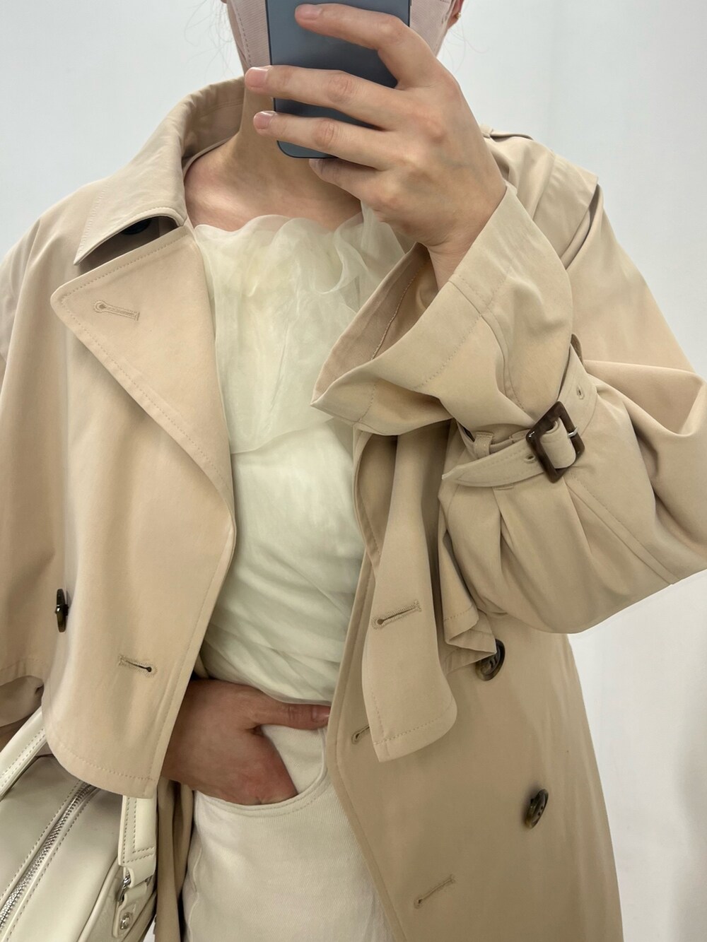 ホワイト系のデニムパンツ、ホワイト系のトレンチコート、ピンク系のシャツ/ブラウスを着用したレディースの冬コーディネートの2枚目の写真