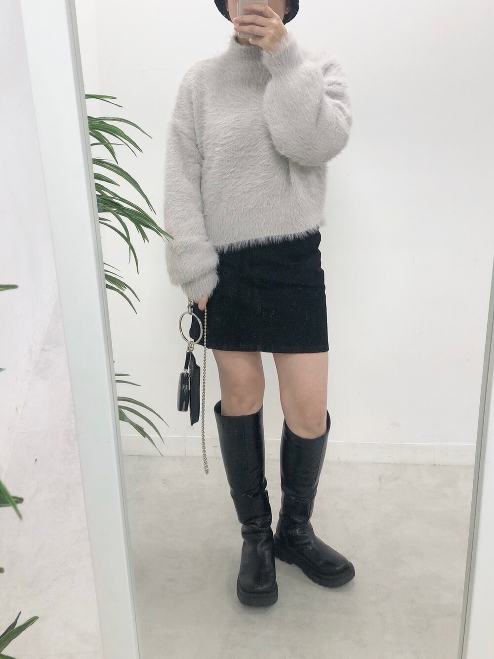 ホワイト系のニット/セーター、ブラック系のスカート、ブラック系のブーツを着用したレディースの冬コーディネートの2枚目の写真