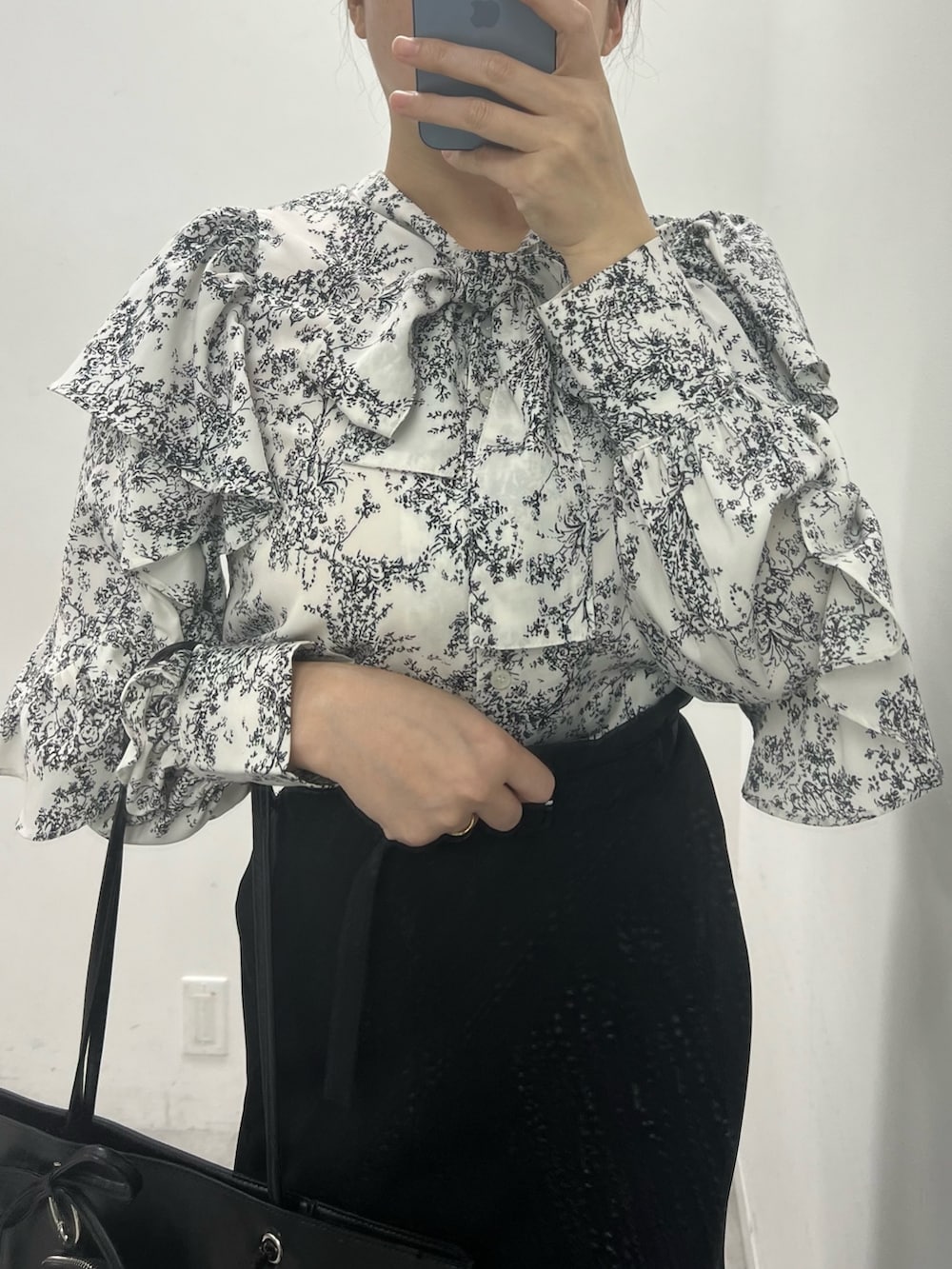 ブラック系のスカート、ブラック系のシャツ/ブラウス、ブラック系のトートバッグを着用したレディースの冬コーディネートの2枚目の写真