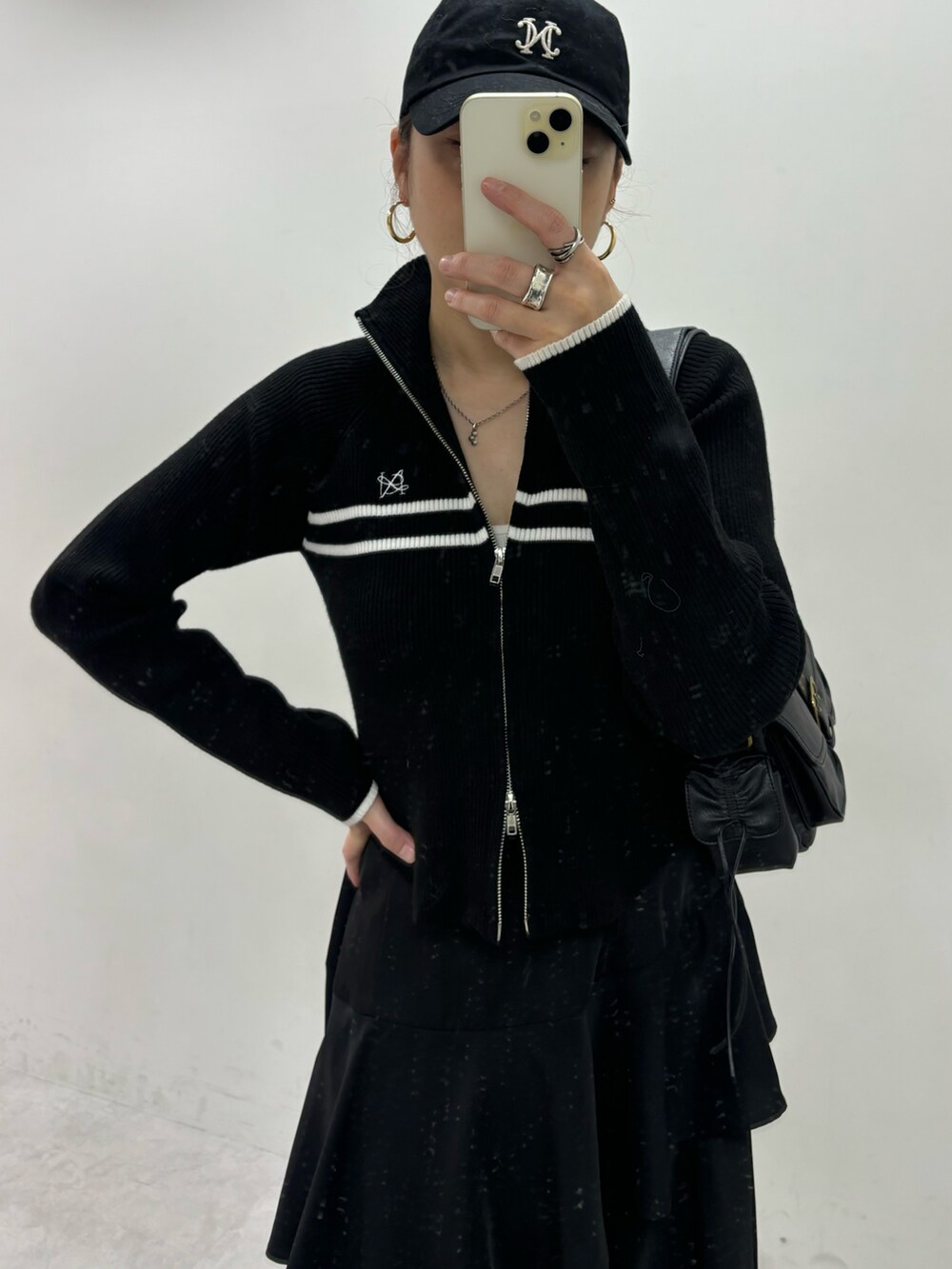 ブラック系のスカート、ブラック系のニット/セーター、グレー系のスニーカーを着用したレディースの秋コーディネートの5枚目の写真