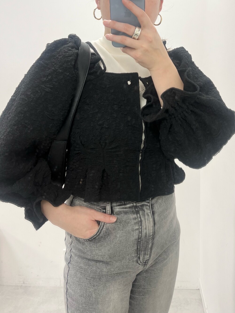 ブラック系のデニムパンツ、ブラック系のブーツ、ブラック系のアンサンブルを着用したレディースの冬コーディネートの2枚目の写真